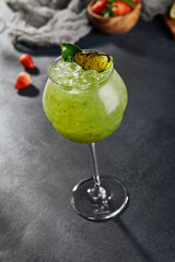 Kiwi spritz cocktail. Dark stone table.