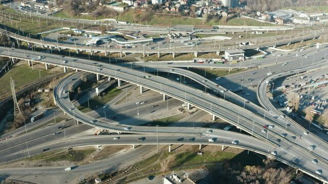 Drone footage of top view of Highway road junctions. The Intersecting freeway road overpass. Busy Downtown Route Development City Highway Junction Overview. Cityscape Car Motion Transport. 