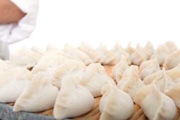 Fototapeta na wymiar White flour dumplings wrapped on a tray in front of white background