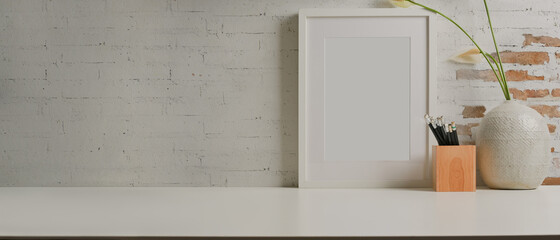 Worktable with mock up frame, stationery, vase and copy space in home office room