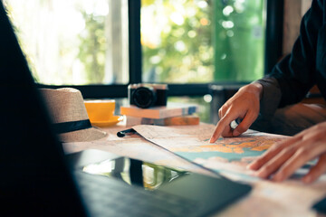 Tourist planning vacation with map and other travel accessories on the table. Travel, holiday, vocation concept.