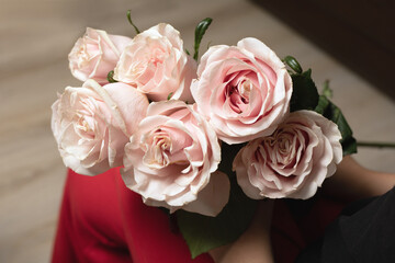 happy girl holding bouquet of pink roses in her hands