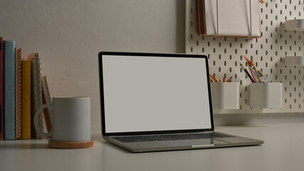 Cropped shot of workspace with laptop, stationery and supplies in home office room