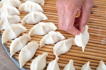 Put the wrapped dumplings on a circular tray with one hand