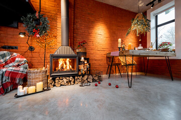 Fototapeta na wymiar Beautiful loft-style interior with a fireplace and a dining table decorated for the New Year holidays