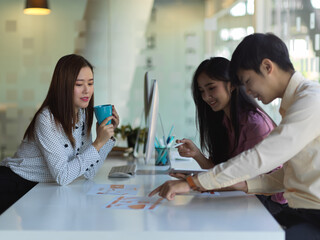 Portraits of UI developer team meeting on their project with tablet and paperwork