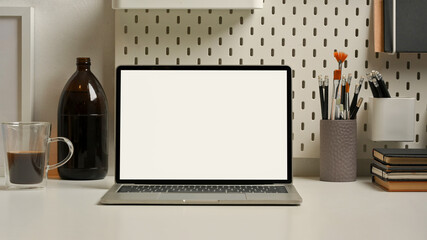 Worktable with laptop, stationery, supplies and decorations in home office