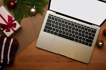 Top view of wooden table with laptop and decorations in Christmas concept