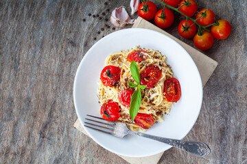 Pasta, spaghetti with tomato sauce in white bowl on old wood background. Copy space.