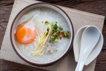 Delicious Rice soup with meat, egg and herbs on old kitchen table with copy space.,hot food and healthy meal concept