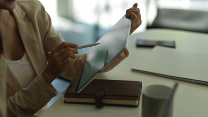 Businesswoman working with tablet on worktable in office room
