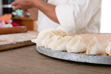 Fototapeta na wymiar Chinese women busy making dumplings in the kitchen during festivals