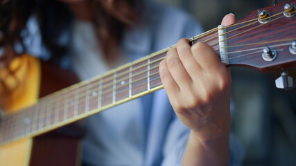 Woman hand playing chords on guitar. Girl fingers strumming strings on guitar