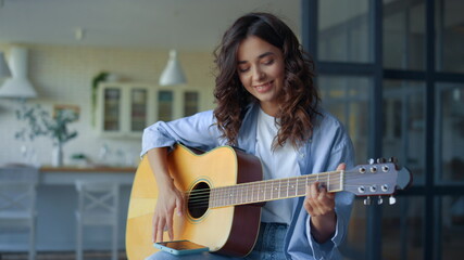 Girl playing guitar. Female guitarist recording guitar sound on mobile phone