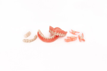 Dentures on a white background. Close-up of dentures. Full removable plastic denture of the jaws. Prosthetic dentistry. False teeth. Close-up of plastic dentures. Teeth on a white background