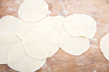 Rolled white flour dumpling wrappers on the chopping board