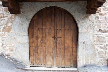 Fototapeta na wymiar old wooden door, it is large and arched, opens in two parts and has a deadbolt