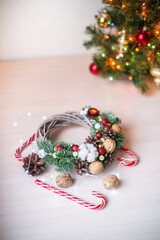 Christmas decoration on a wooden background. Candies. New year's wreath  with nuts, cones and spruce branches