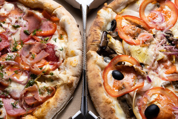 Two different pizzas in a box top view.