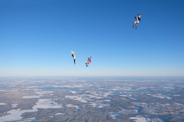 Skydiving. Three skydivers are in the sky.