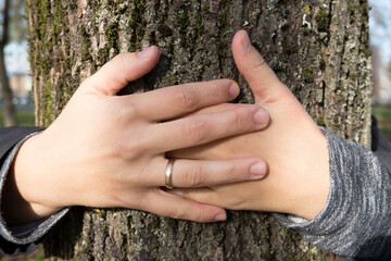 Girl's hand is embracing the tree. concept of nature and environment protection.