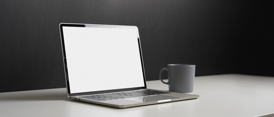 Cropped shot of workspace with tablet, laptop, books and decorations in home office room