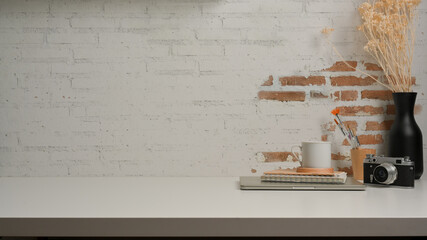 Worktable with camera, supplies, vase and copy space in home office room
