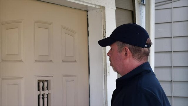 Man knocks on the front door of a residence and delivers eviction notice