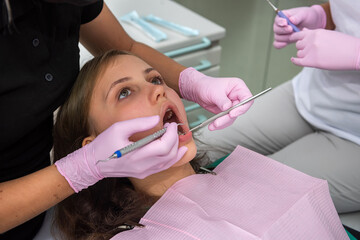 female dentist examining a patient's teeth in the clinic