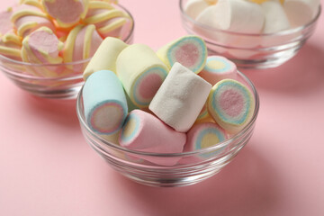 Bowls with marshmallow on pink background, close up