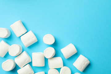 Sweet marshmallow on blue background, space for text