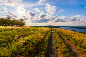 Obraz premium Path of relaxation. Dirt road parallel with big river
