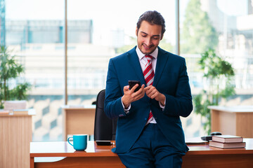 Young handsome employee working in the office