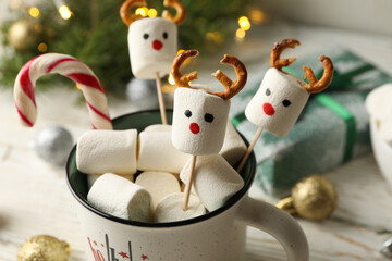 Cup with marshmallow on Christmas wooden background