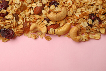Tasty granola on pink background, space for text
