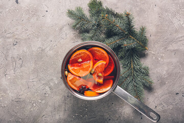 Saucepan with hot mulled wine on grunge background