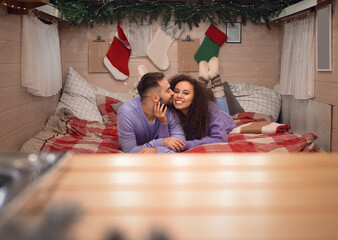 Obraz na płótnie Canvas Happy young couple celebrating Christmas in motorhome