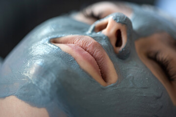 young woman relaxes in a beauty spa after applying a mask on her face