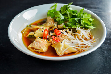 Boiled meat dumplings with fresh parsley, soy sauce and sesame seeds. Delicious meal for dinner.