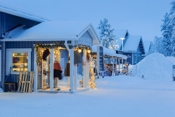 Street view of a Finnish town Saariselka in winter, snow-covered cottages and shops on the street