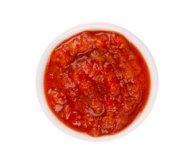 Adjika sauce in bowl, isolated on white background. Spicy tomato and chili pepper sauce. Top view.