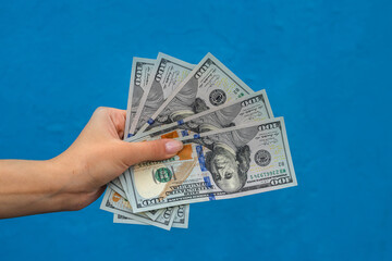 Businesswoman with dollars isolated on blue