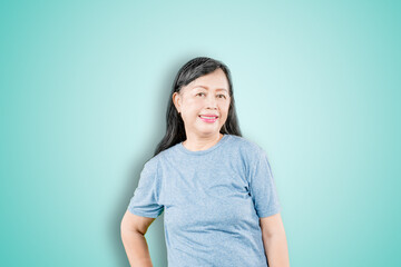 Fototapeta premium Elderly woman smiling at the camera on studio