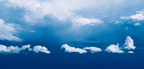 Blue sky with white clouds above the horizon