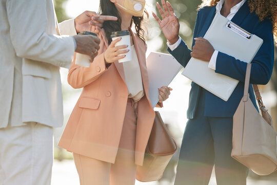 Cropped image of young business people standing outdoors and discussing work during coffee break
