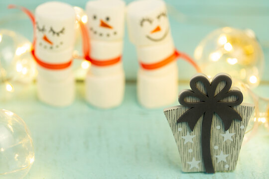decorative gifts with ribbons on the background of blurred marshmallow snowmen, Christmas blurred background with gifts