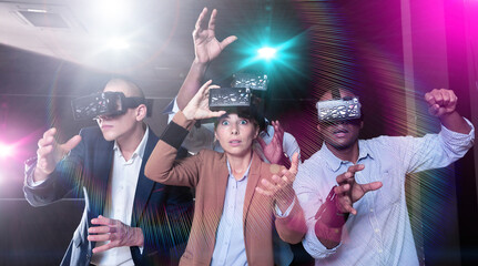 Four friends of different nationalities using virtual reality headset and gesturing