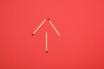 arrow-shaped matches on a red background copy space