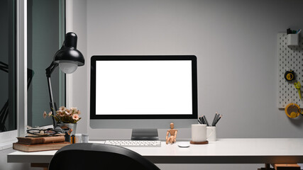 Creative designer workspace with a computer and equipment on white table. Blank screen for graphics display montage.