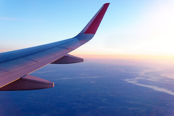 Fototapeta premium plane flying above the clouds. View from the wing of the plane. Travel concept
